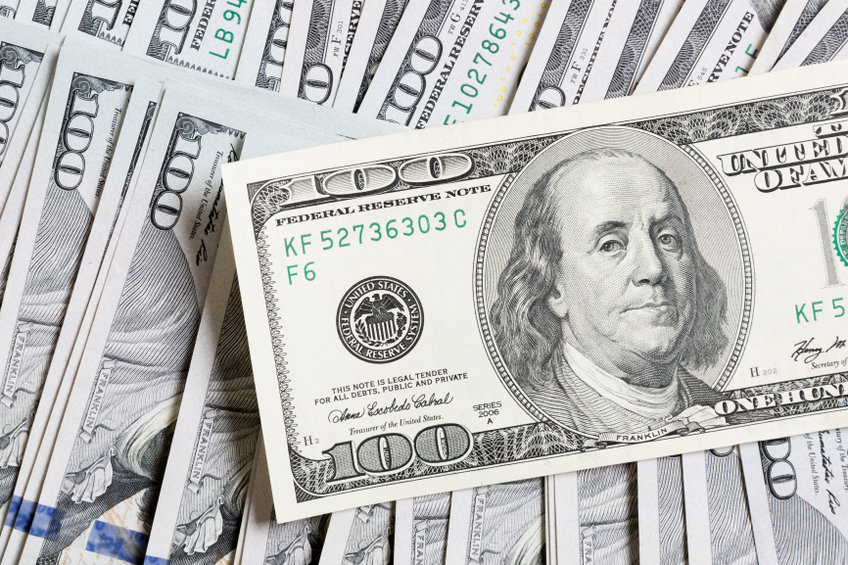 100-Dollar-Schein, im Hintergrund liegen weitere Dollar-Scheine.