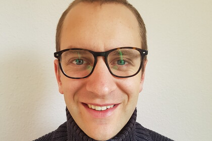 Portrait von Jakob Lehr. Er trägt Brille und einen dunkelblauen Pullover.