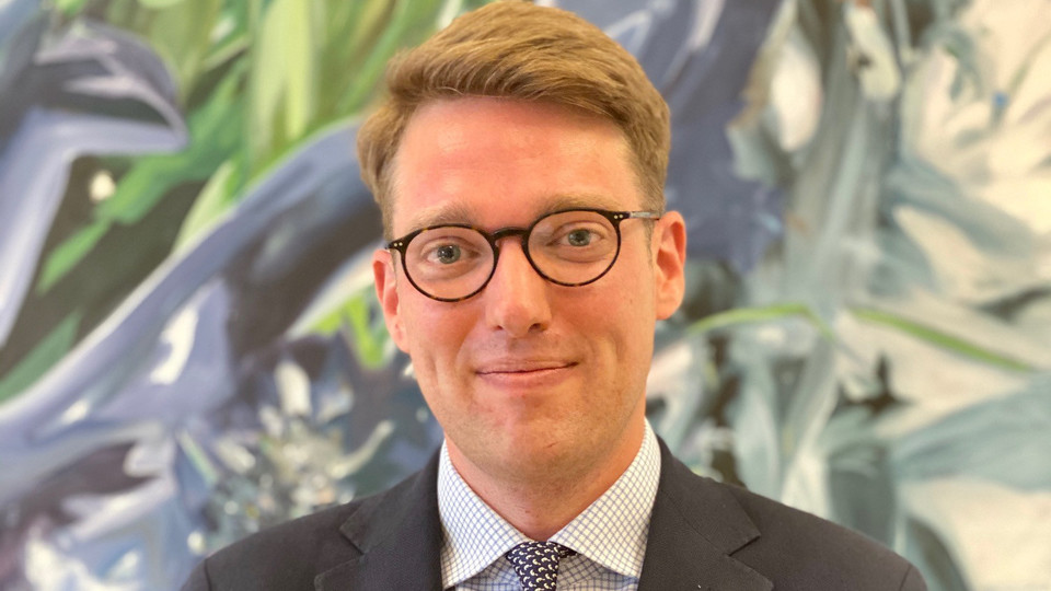prof. Vetter hat blonde kurze Haare und trägt eine Brille. Er trägt ein Anzug mit Krawatte.