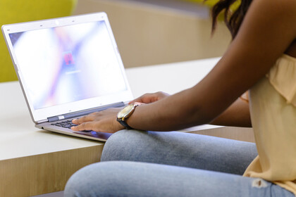 Eine Studentin meldet sich an ihrem Laptop an.