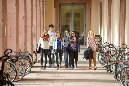 Eine Gruppe von Studierenden läuft durch einen Gang auf dem Ehrenhof