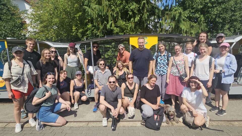 Das Team des Otto-Selz-Instituts steht lächelnd vor einer Draisine
