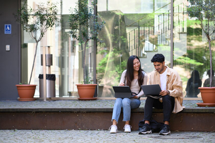 Zwei Studierende arbeiten an ihren Laptops. 