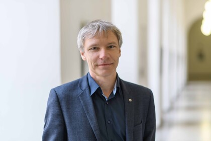 Stefan Münzer trägt ein blaues Sakko und ein blaues Hemd.