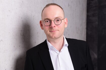 Portraitfoto von Dr. Constantin Wurthmann. Er trägt ein weißes Hemd und ein schwarzes Sakko.