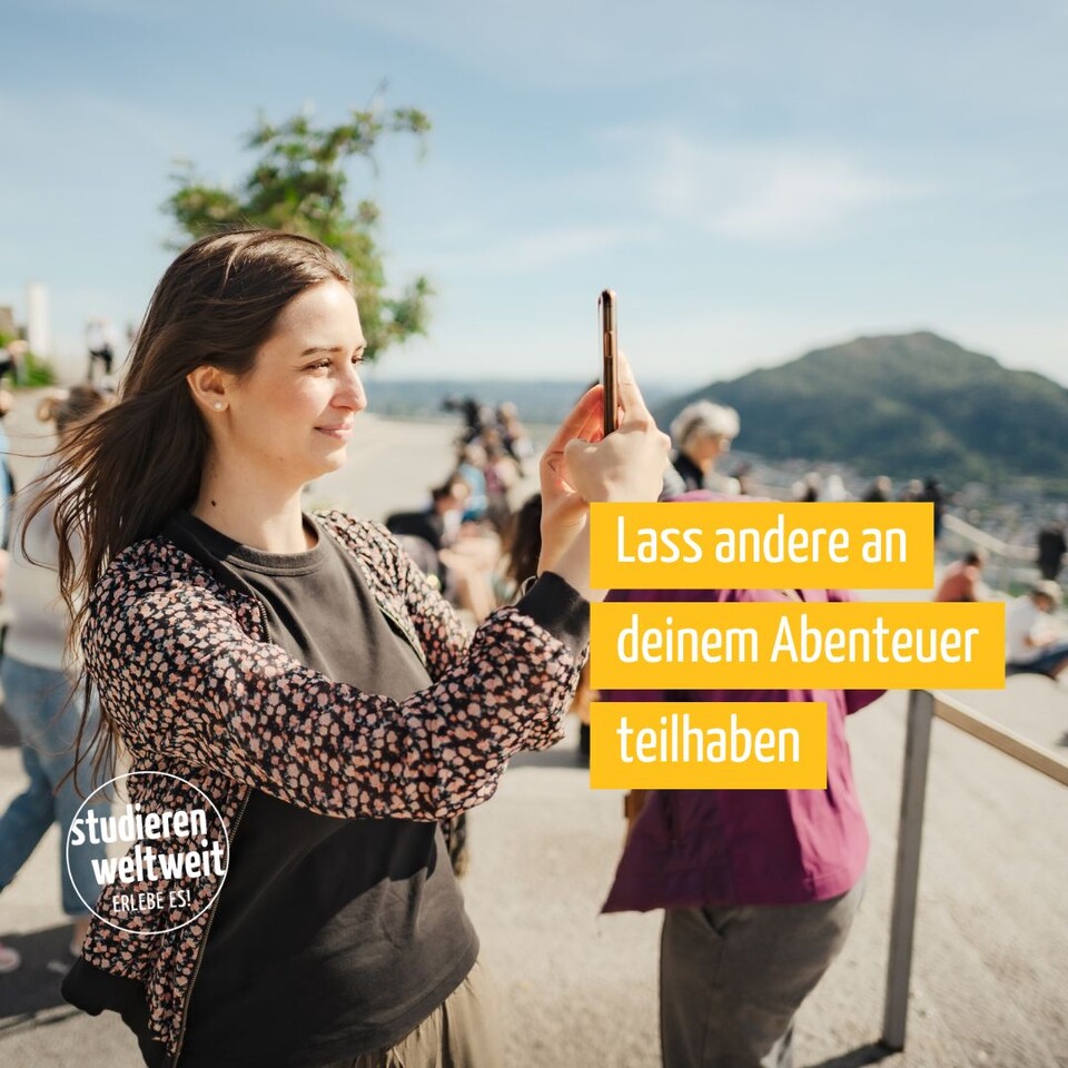 Frau macht im Freien ein Foto mit dem Smartphone; im Bild hervorgehoben der Text ‚Lass andere an deinem Abenteuer teilhaben‘ und ein ‚studieren weltweit – Erlebe es!‘-Logo.