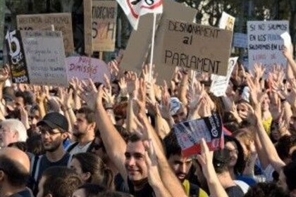 Bei einer Demonstration werden mehrere Pappschilder in die Höhe gehalten.
