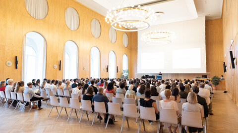 Aula der Universität Mannheim mit Stühlen und Absolvent:innen