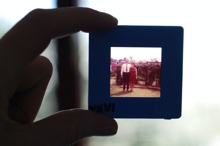 Zwei Finger halten den Rahmen eines Bildes. Auf diesem älteren Foto sind ein Mann und eine Frau zu sehen.