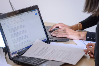 Zwei Frauen arbeiten an ihren Laptops.