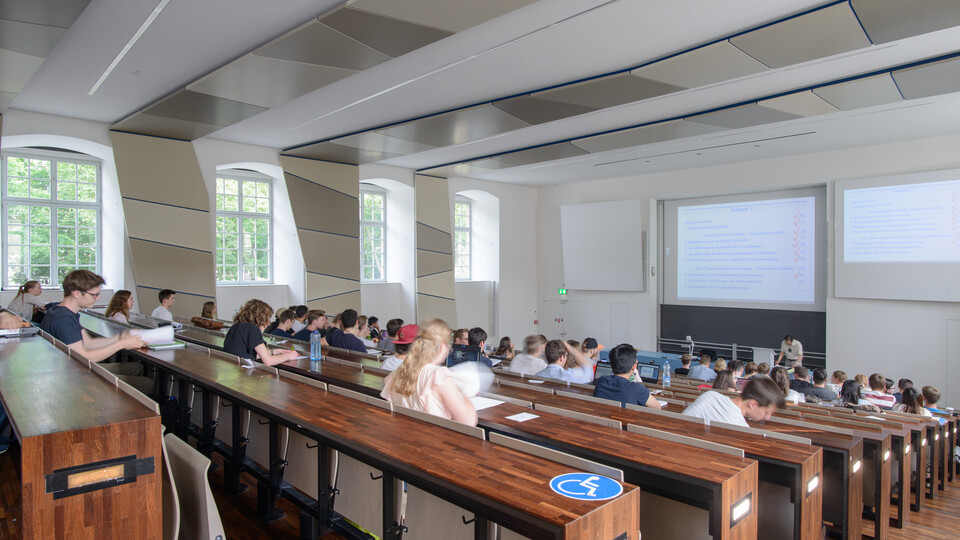 Studierende hören einem Vortrag zu.