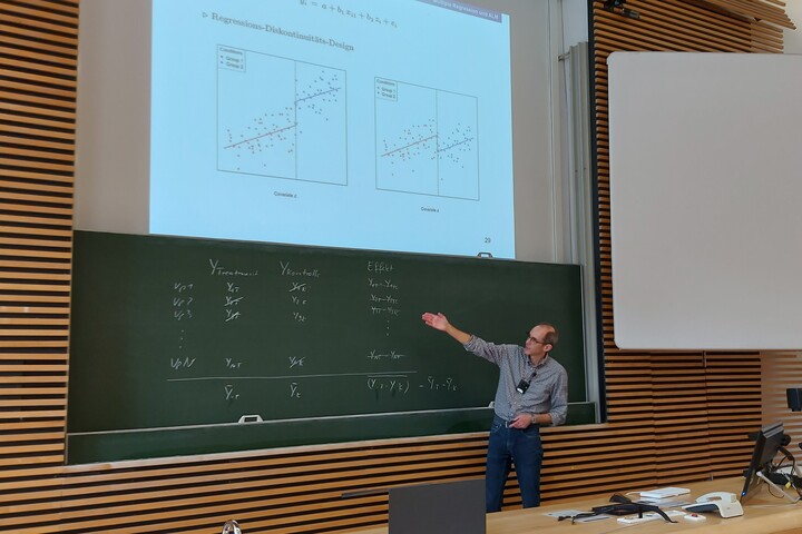 Professor teaching statistics using the blackboard