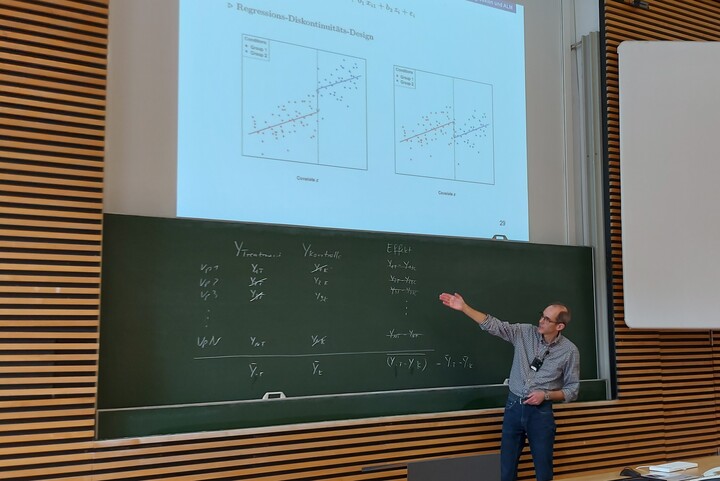 Professor teaching statistics using the blackboard