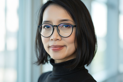 Portrait von Eirliani Rahman. Sie trägt einen schwarzen Bob und eine Brille. 