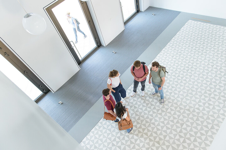 Eine Gruppe Studierender steht im Foyer des B6-Gebäudes.