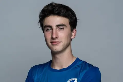Herr Hinrichs hat kurze braune Haare, trägt ein Sport-Trickot und hat die Arme vor der Brust verschränkt