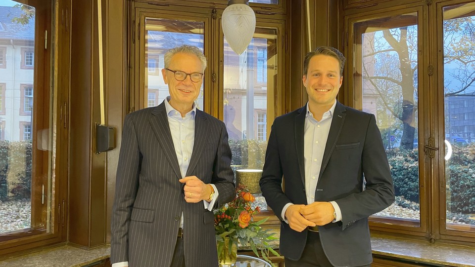 Prof. Glenk und Dekan Lutz stehen vor einer Fensterwand