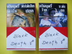 Zwei Zigarettenpackungen mit überklebten Notizzetteln der Aufschrift "Black Death".