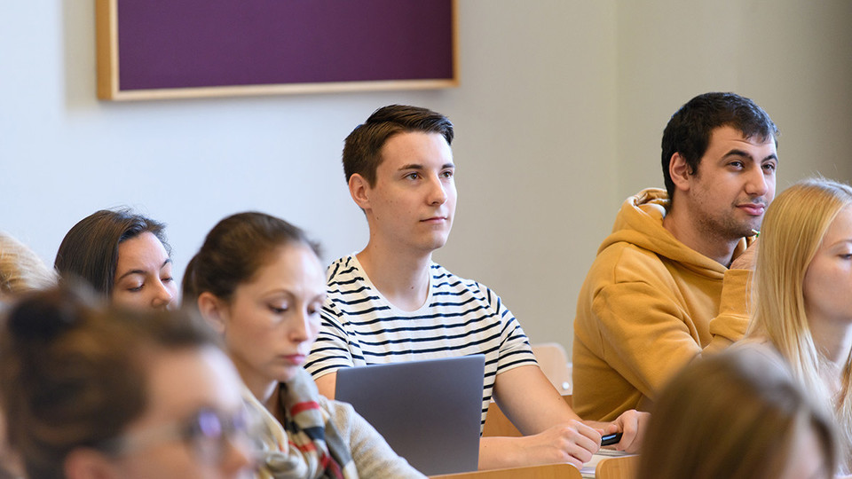 Studierende sitzen aufmerksam im Hörsaal.