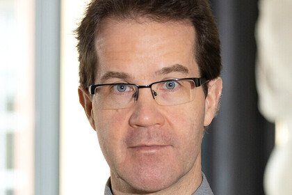 Portrait von Christian Mann. Er trägt eine Brille mit schwarzem Rahmen.