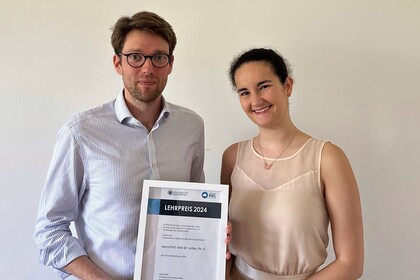 Eine Vertreterin der Fachschaft überreicht Prof. Vetter den Fachschaftslehrpreis