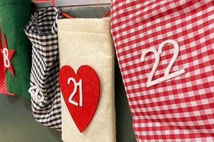 Adventskalender-Tüten hängen an einer Wand.