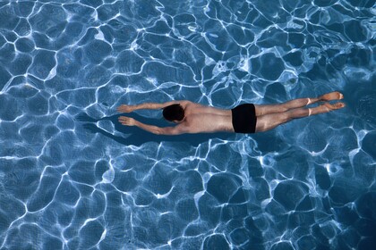 Ein Mann taucht in einem Swimming-Pool
