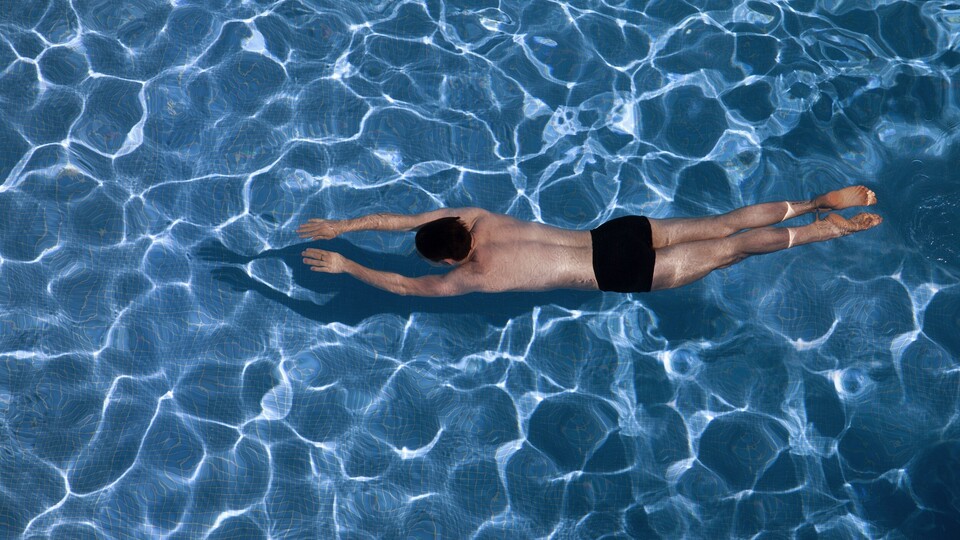 Ein Mann taucht in einem Swimming-Pool