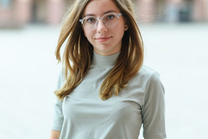 Porträt der Studentin Valeria Lebedieva in der Reihe #testimonialtuesday. Valeria hat halblange hellbraune Haare, die ihr in Wellen über die Schulter fallen. Sie trägt eine Hornbrille mit hellem Gestell und ein mitfarbenes T-Shirt. Link: Instagram-Story Testimonial Tuesday