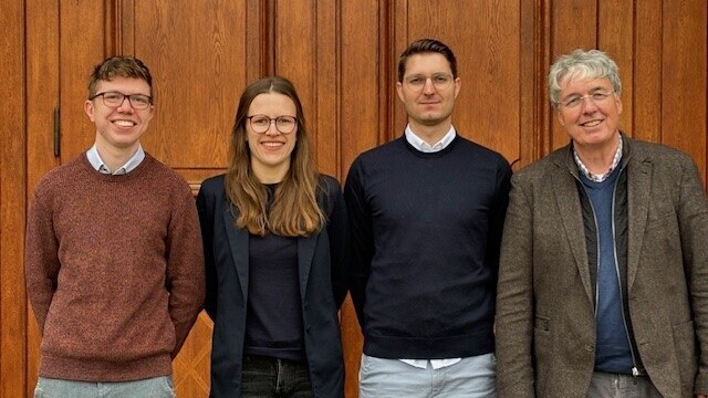 The M2Olie Research team, consisting of four persons, stands in front of the Mannheim Palace.