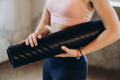 Eine Sportlerin trägt ein rosanes Sport-Oberteil und eine blaue Sporthose. Sie hält eine Fitnessmatte in der Hand. Unten rechts steht "IFS. Institut für Sport. Universität Mannheim"