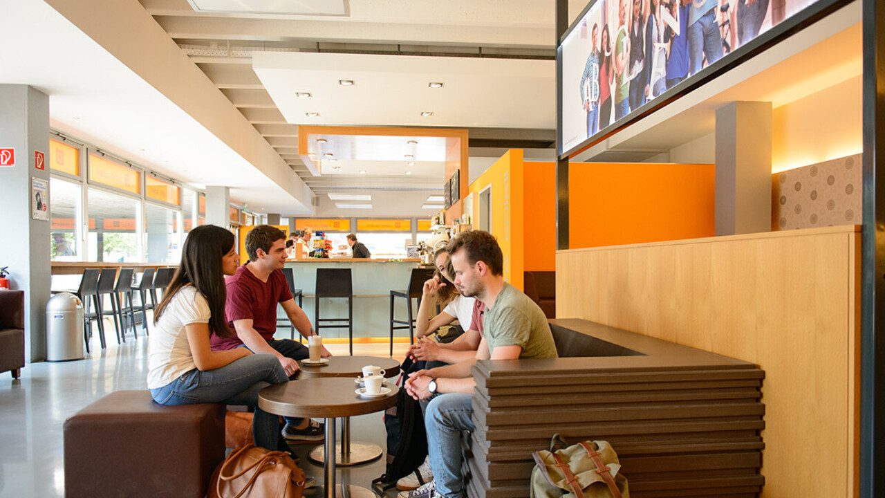 Eine Gruppe Studierender sitzt im Café Soleil.
