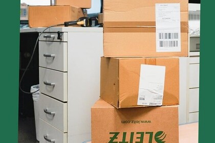 Blick auf ein Büro mit vielen Kartons. Oben links steht "Green Uni Ma".