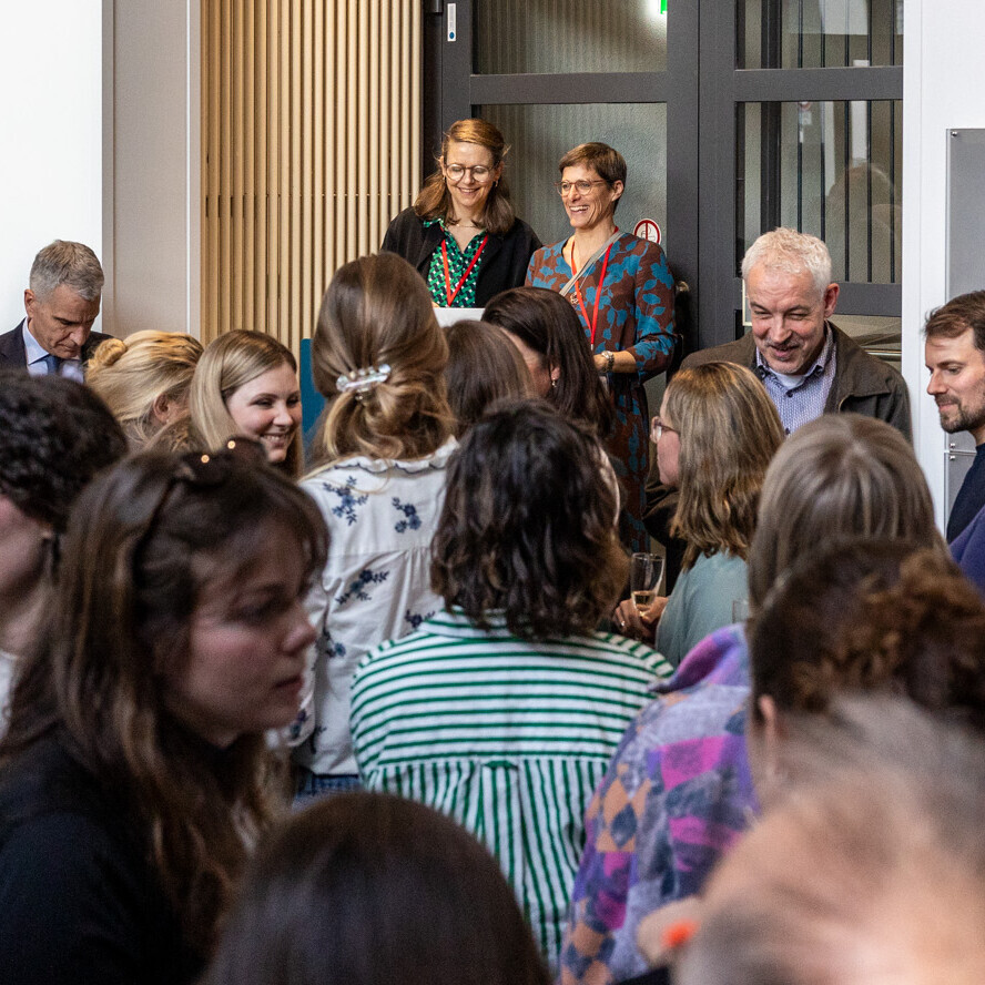 Die Leiterinnen der neuen Hochschulambulanzen stehen bei der Eröffnung an einem Pult. Vor ihnen stehen viele Menschen.