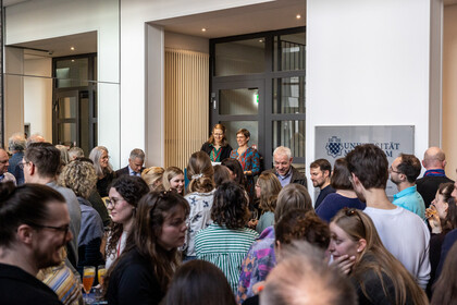 Die Leiterinnen der neuen Hochschulambulanzen stehen bei der Eröffnung an einem Pult. Vor ihnen stehen viele Menschen.
