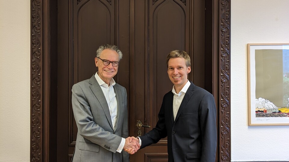 Dekan Lutz schüttelt einem Juniorprofessor die Hand