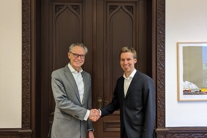 Dekan Lutz schüttelt einem Juniorprofessor die Hand