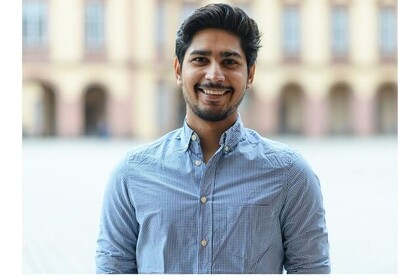 Porträt des internationalen Studenten Vishal Sharma in der Reihe "testimonialtuesday". Chan trägt ein graues langärmeliges Hemd und kurze schwarze Haare. Er lacht offen in die Kamera. Link: Instagram Post testimonialtuesday