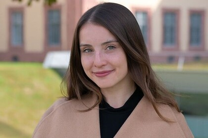 Porträt der Studentin Valeria aus Mainz. Sie trägt ein cremefarbenes Oberteil und hat ihre braunen, schulterlangen Haare offen. Sie lacht freundlich in die Kamera. Link: Instagram myUniMA story Oktober 2022