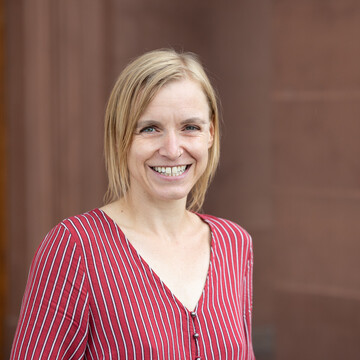 Miriam Kucher hat blonde, schulterlange Haare und trägt eine rot-weiß-gestreifte Bluse.