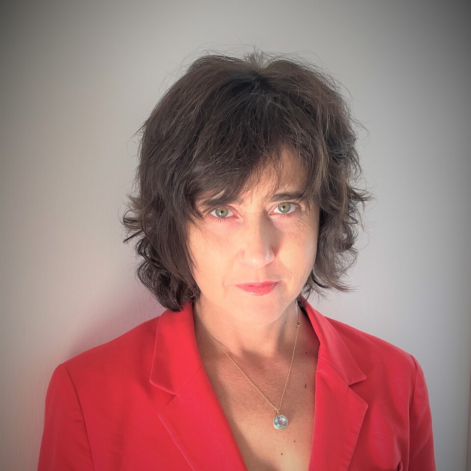 Portrait von Irena Kogan. Eine Frau mit dunklen Haaren und einer roten Bluse.