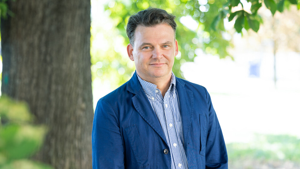 Prof. Henning Hillmann. Er schaut freundlich drein und trägt ein blaues Jacket über einem gestreiften Hemd.