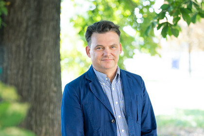 Prof. Henning Hillmann. Er schaut freundlich drein und trägt ein blaues Jacket über einem gestreiften Hemd.