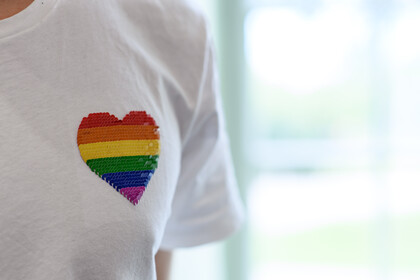 T-Shirt mit aufgedrucktem Herz in Regenbogenfarben.