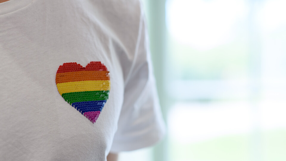 T-Shirt mit aufgedrucktem Herz in Regenbogenfarben.