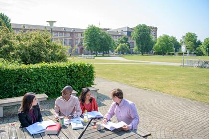 Vier Studierende lernen auf dem Außengelände der Universität Mannheim