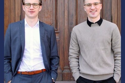 Silas und Sören Lars Hengstberger stehen nebeneinander vor dem Mittelbau der Universität Mannheim. Darunter steht "Hashtag 10 Jahre Deutschlandstipendium".