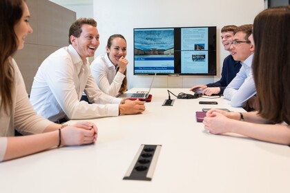 Menschen in Business Kleidung sitzen um einen Tisch