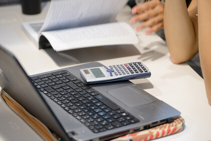 Laptop und Taschenrechner auf einem Tisch
