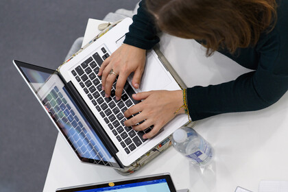 Eine Frau tippt auf einer Tastatur.